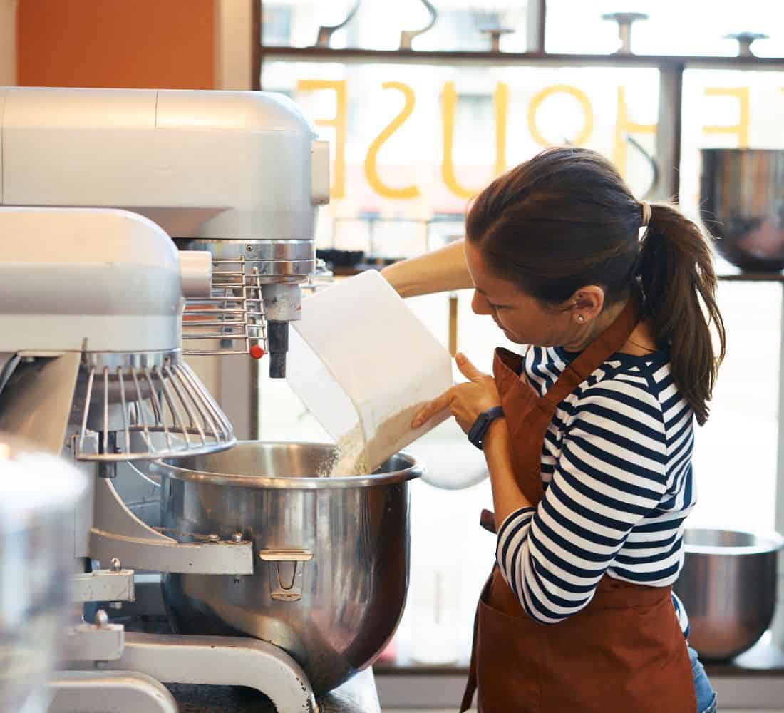 A Signorelli baker pouring flour into a mixing bowl