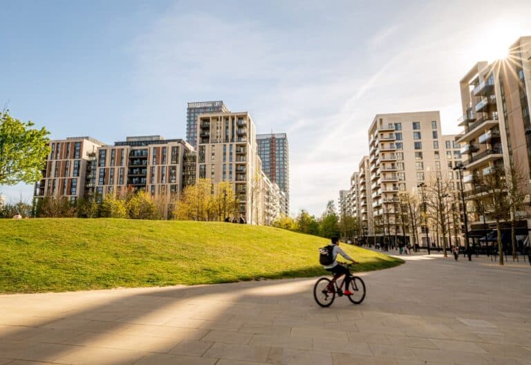 A person riding their bike on a sunny day by Victory Park in East Village