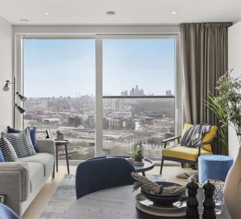 A decorated living room of a Portlands Place home with a balcony view of the London city skyline