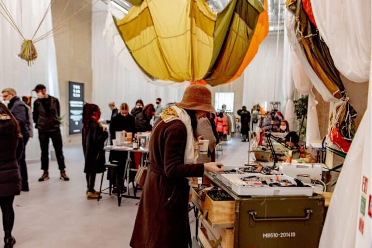 A person looking a trunk of Christopher Raeburn branded materials at The Lab E20 in East Village