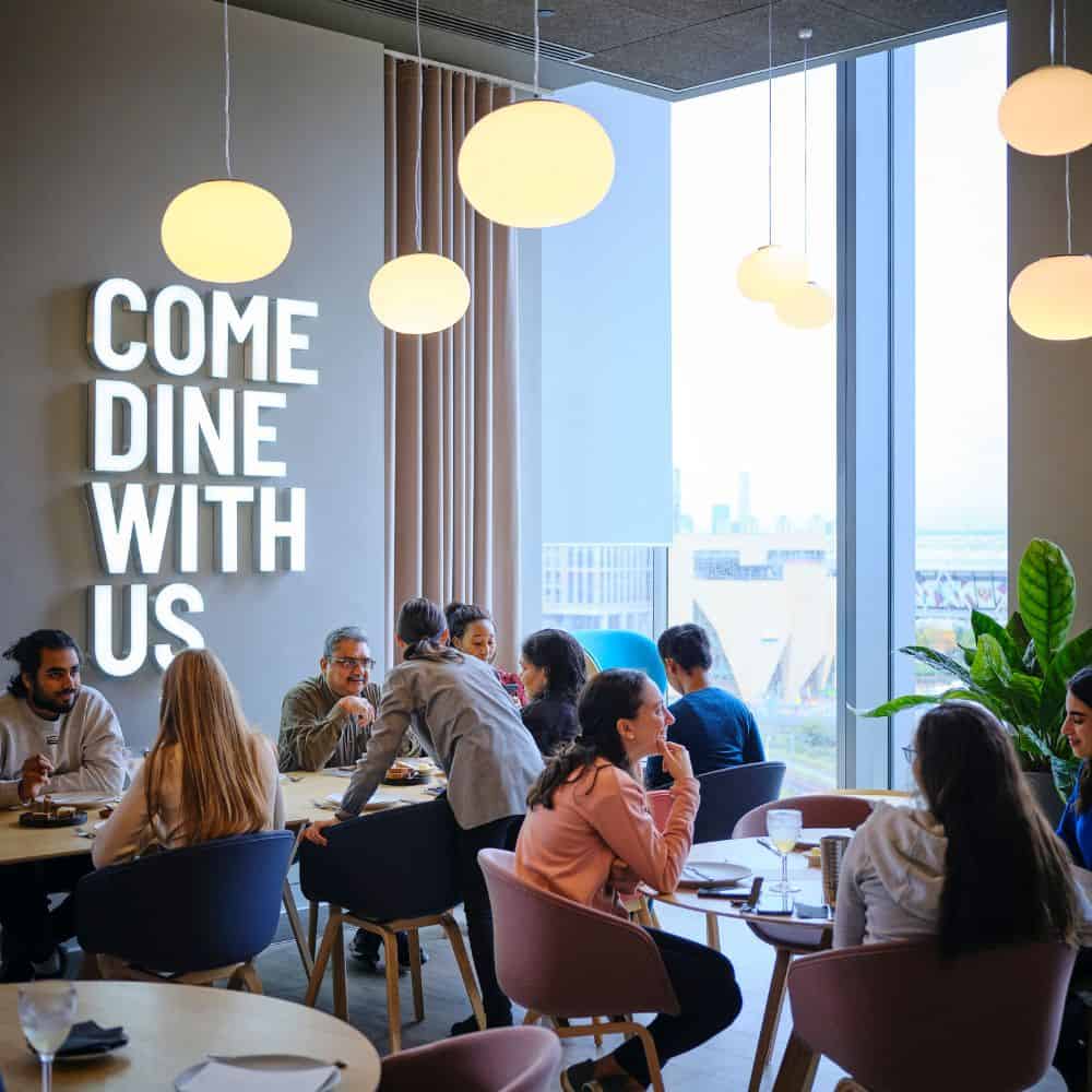 Groups of people sitting in the communal Come Dine With Us kitchen in Portlands Place, East Village