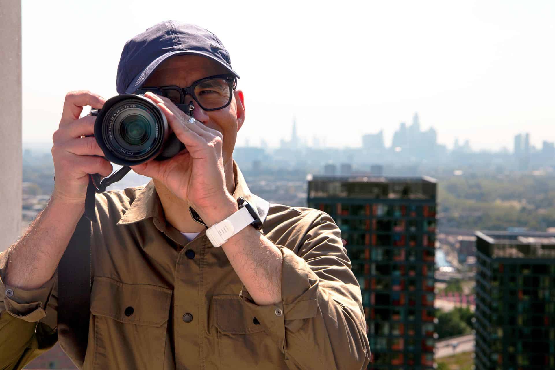Photographer Frank Da Silva taking a picture with East Village apartment buildings in the background